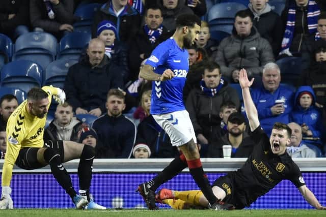 Livingston's Bobby Burns goes down in the box under a challenge from Allan McGregor. Pic: SNS
