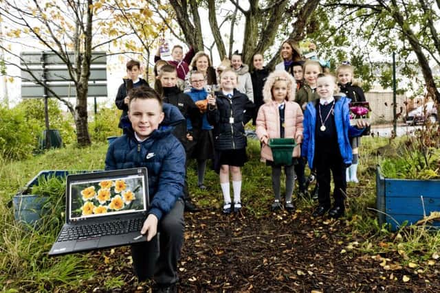 Taylor Wimpeys Lisa Brander and class teacher Carole Wood help the children of Holytown Primary plant the 300 spring bulbs