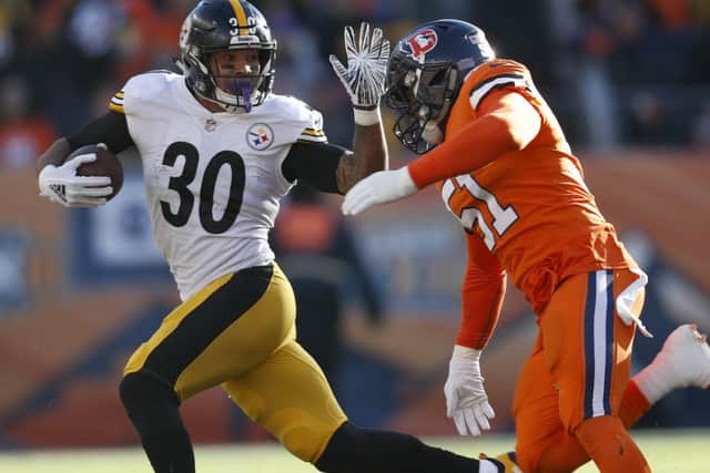 Pittsburgh Steelers running back James Conner tries to elude Denver's Todd Davis. Picture: AP