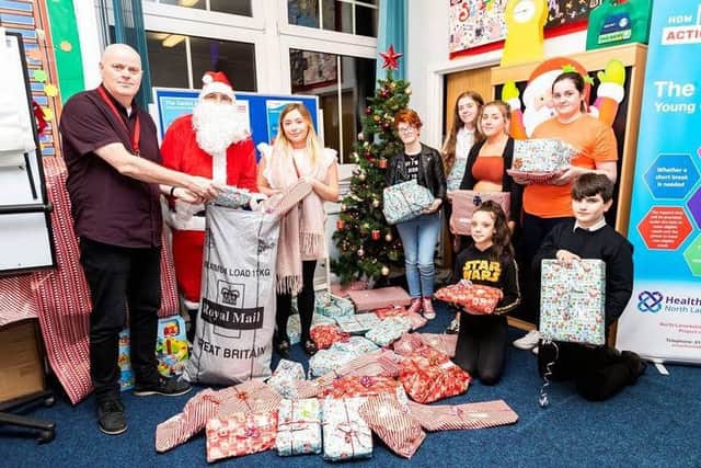 Royal Mails David Goldie helps Father Christmas deliver the Secret Santa presents to young carers in North Lanarkshire