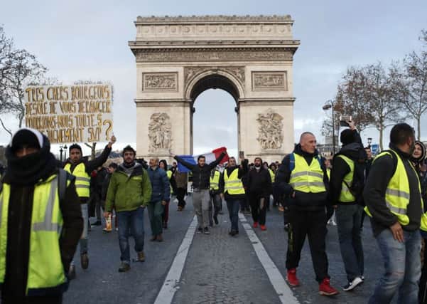 Demonstrators wearing yellow vests march down the Champs Elysees. (AP Photo/Thibault Camus)