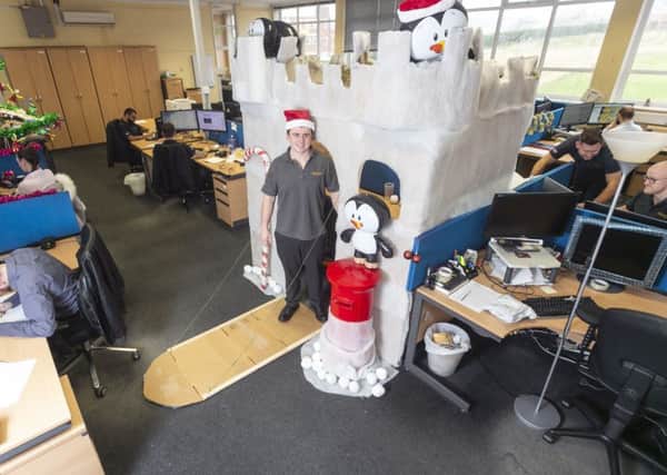 Jack Makepeace, 24 who has constructed a Christmas castle around his desk. Picture: SWNS