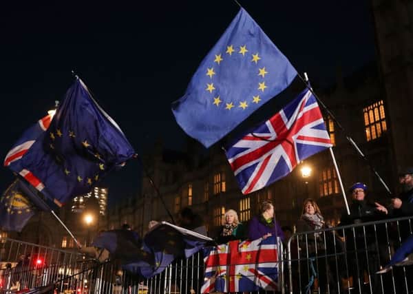 Anti-brexit campaigners wave Union and EU flags outside the Houses of Parliament in central London. Picture: Daniel Leal-Olivas/AFP