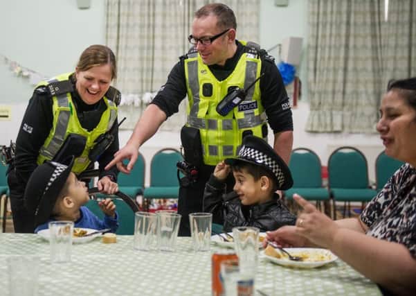 PC Harry O'Donnell and PC Laura Ferguson chat to Romanian children at the Community Canteen at Trinity Church in Govanhill. Photograph: John Devlin