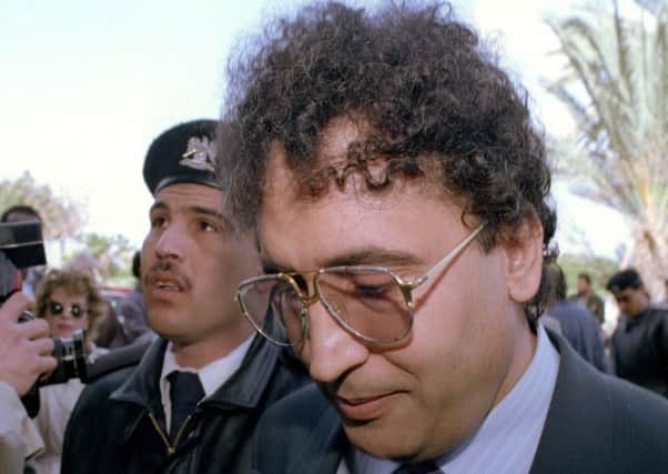 Abdel Basset Ali al-Megrahi, right, is escorted by a police officer to court in Tripoli, Libya, in this Feb. 18, 1992. (AP PHOTO/Jockel Fink)
