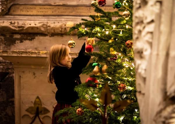 The final decorations being placed on by young Emma Sharp at Rosslyn Chapel.