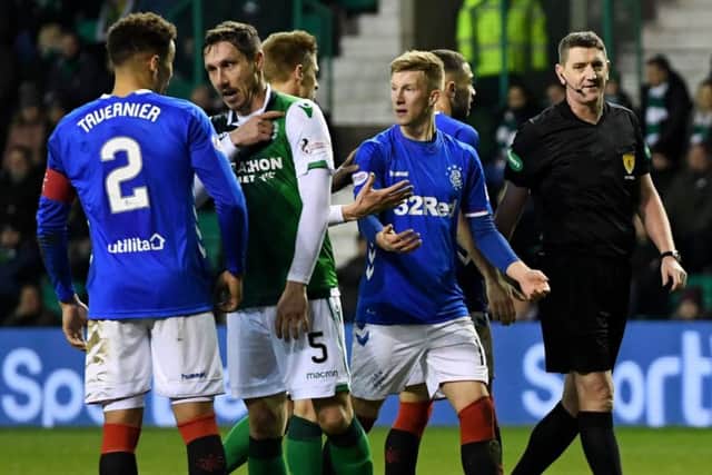 Hibs midfielder Mark Milligan suggests the ball hit him on the shoulder as Rangers players appeal for a penalty at Easter Road