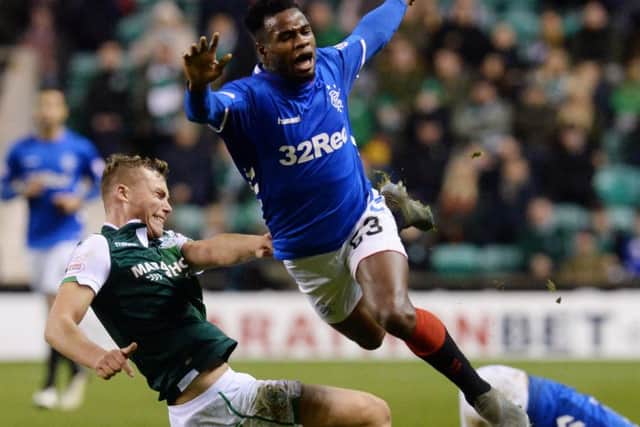 Hibernian's Ryan Porteous was booked for this tackle on Rangers' Lassana Coulibaly. Picture: Ross MacDonald/SNS