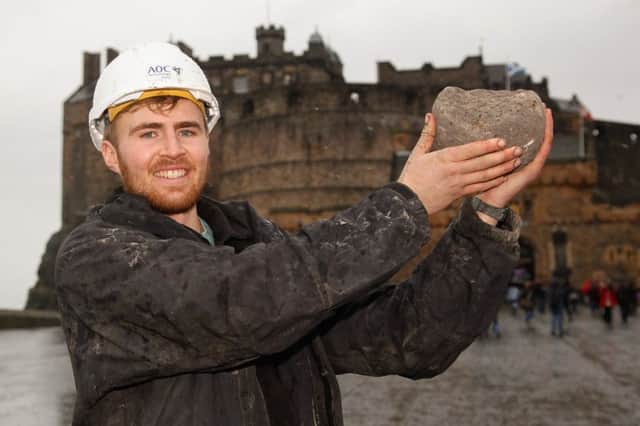 Archaeologist Samuel Kinirons with the stone catapult ball believed to have been fired during the siege of Edinburgh Castle. Picture: Scott Louden