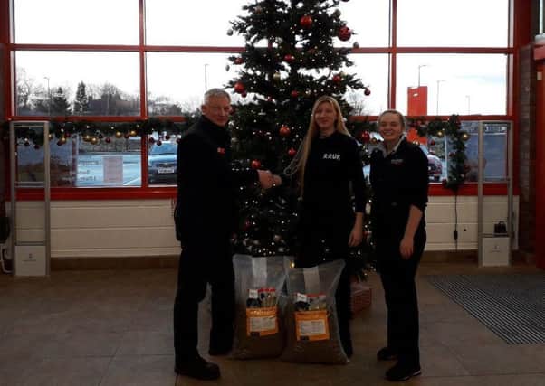 Meghan Mackey (centre) receiving some of the donations from Harbro Dalkeith Manager Ian Paterson and retail assistant Abbie Boyd-Ellison.