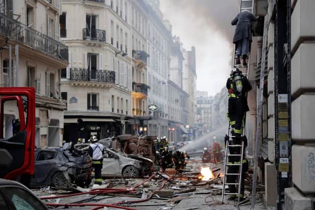 A woman is evacuated by firefighters from an apartment after the explosion of a bakery on the corner of the streets Saint-Cecile and Rue de Trevise in central Paris. Picture: AFP/Getty Images
