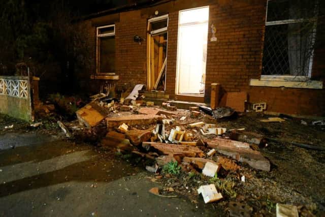 A dad was rushed to hospital after a bus smashed into his car and dragged it into a nearby house. Picture: SWNS