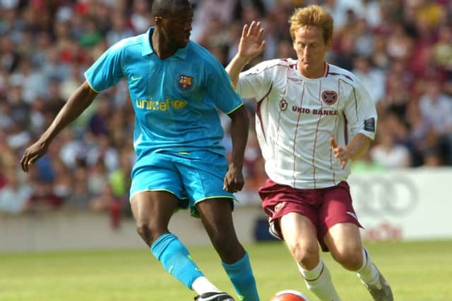 Yaya Toure, during his Barcelona days, sees off a challenge from Michael Stewart in a friendly match against Hearts. Picture: Julie Howden