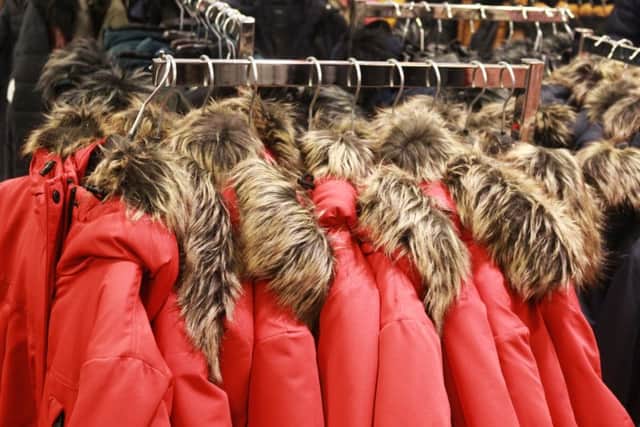 Red jackets with a fake fur collar hanging in a store