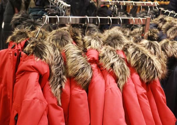 Red jackets with a fake fur collar hanging in a store