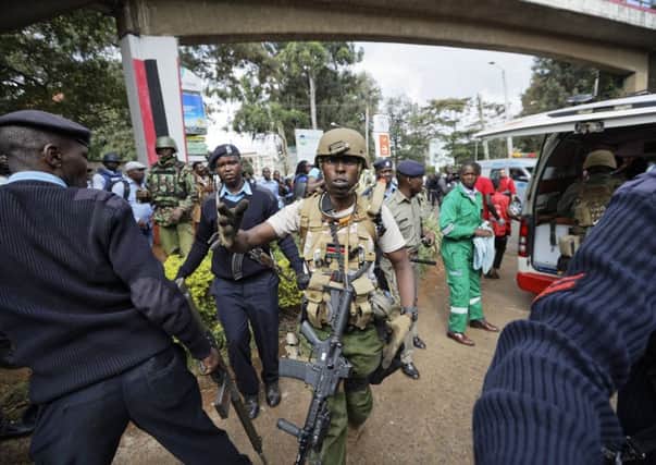 A member of Kenyan special forces shouts at the media to go back after his wounded colleague was carried into an ambulance. Picture: AP Photo/Ben Curtis