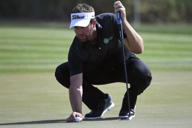 Scott Jamieson places the ball on the 16th green during his second-round 66 in Abu Dhabi. Picture: Martin Dokoupil/AP