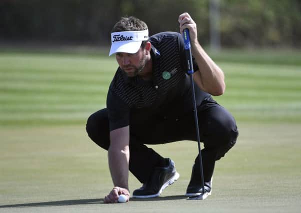 Scott Jamieson places the ball on the 16th green during his second-round 66 in Abu Dhabi. Picture: Martin Dokoupil/AP
