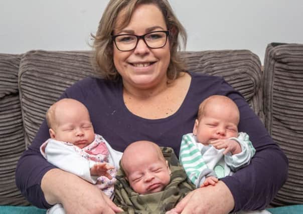 Beata Bienias, 36 who lost five stone in order to get pregnant by IVF and then had triplets, Borris (camo), Amelia (pink) and Matilda (blue). Picture: SWNS
