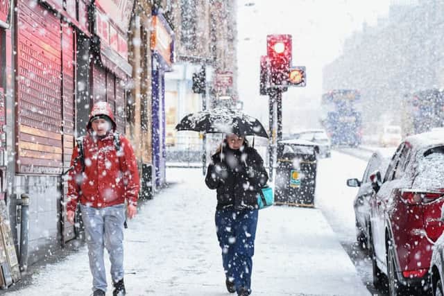 Members of the public make their way through a snow shower in the West End in Glasgow. Picture: Jeff J Mitchell/Getty Images