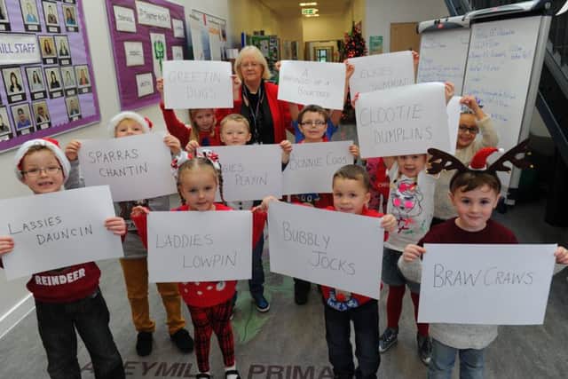 Children at Aileymill Primary in Greennock hold up cards with Scots words used on a Christmas card (Picture: Robert Perry)