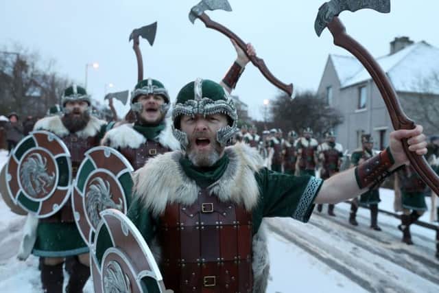 Members of the Jarl Squad cheers as they march through Lerwick as snow falls on the Shetland Isles during the Up Helly Aa Viking festival. Picture: Andrew Milligan/PA Wire