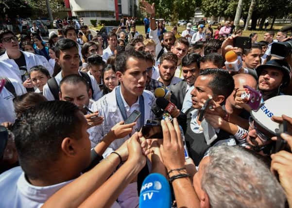 Venezuela's self-proclaimed "acting president" Juan Guaido talks to the media as he takes part in a protest against the government of President Nicolas Maduro (Picture: Luis Robayo/AFP/Getty Images)