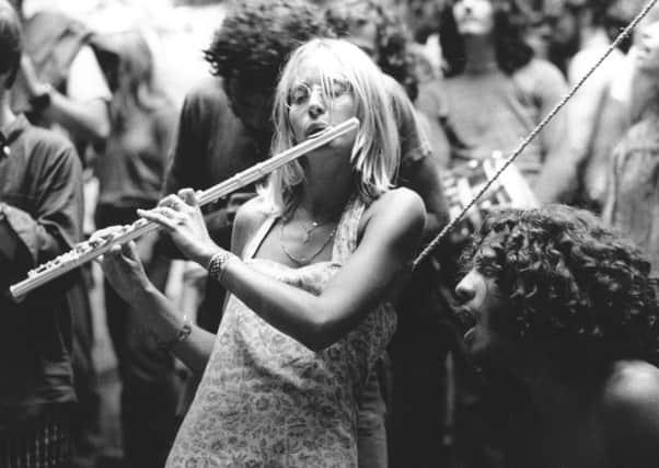 A woman plays a flute at the 1969 Woodstock festival in the US, which inspired countless other similar events around the world (Picture: Granger/Rex/Shutterstock)