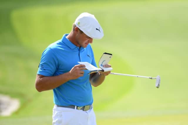 Bryson DeChambeau checks his yardage book during the second round of the Saudi International at Royal Greens. Picture: Getty Images