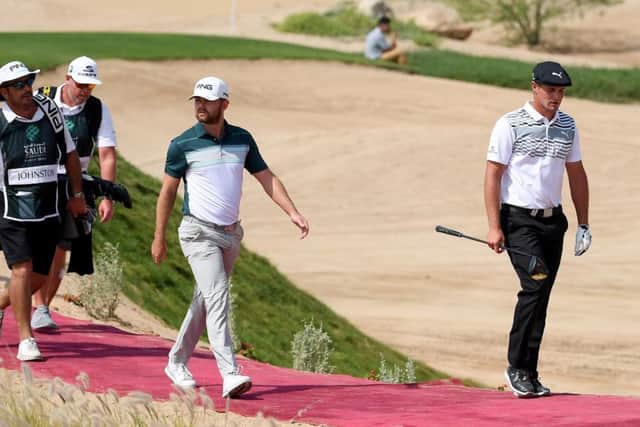 Bryson DeChambeau marches on ahead of Liam Johnston as they walk off the first tee in the Saudi International. Picture: Ross Kinnaird/Getty Images