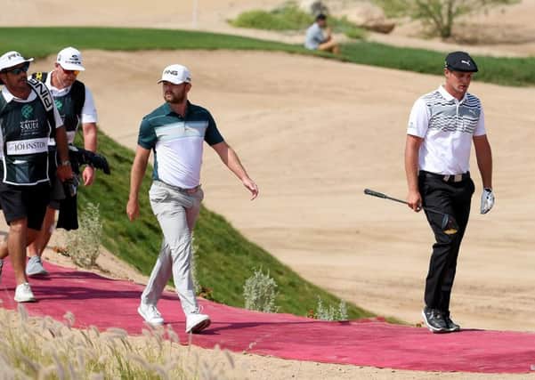 Bryson DeChambeau marches on ahead of Liam Johnston as they walk off the first tee in the Saudi International. Picture: Ross Kinnaird/Getty Images