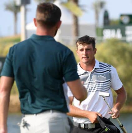 Bryson DeChambeau heads to shake Liam Johnston's hand on the 18th green in the third round of the new European Tour event on the Red Sea coast. Picture: Ross Kinnaird/Getty Images