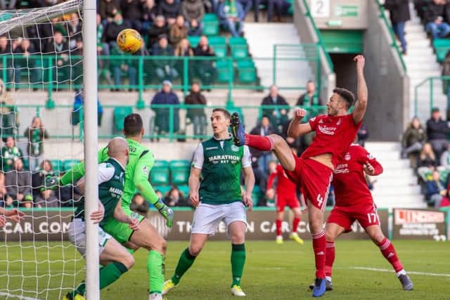 Andrew Considine heads past Ofir Marciano to score Aberdeens equaliser at Easter Road on Saturday. Picture: SNS.