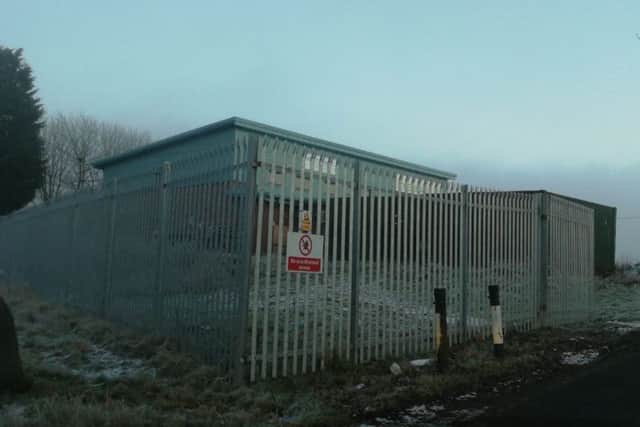 The fence at the business premises in Croy which Historic Environment Scotland says encoraches onto the site of the Antonine Wall. PIC: Contributed.