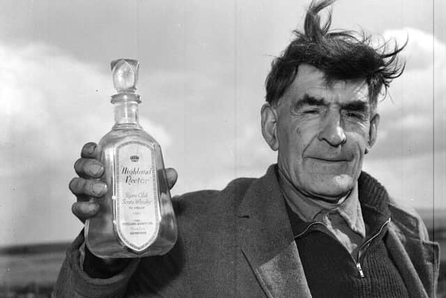 South Uist man John Morrison with an empty bottle of Highland Nectar whisky he liberated from the stricken boat. PIC: TSPL.