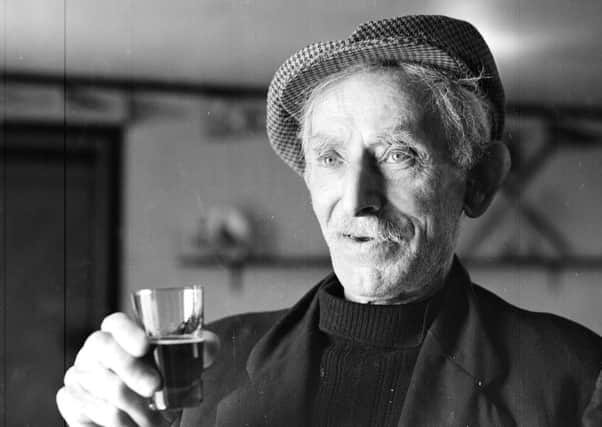 South Uist man John MacIsaac with a glass of Highland Nectar whisky, bottles of which he liberated from the SS Politician  when she went aground in 1941. PIC: TSPL.