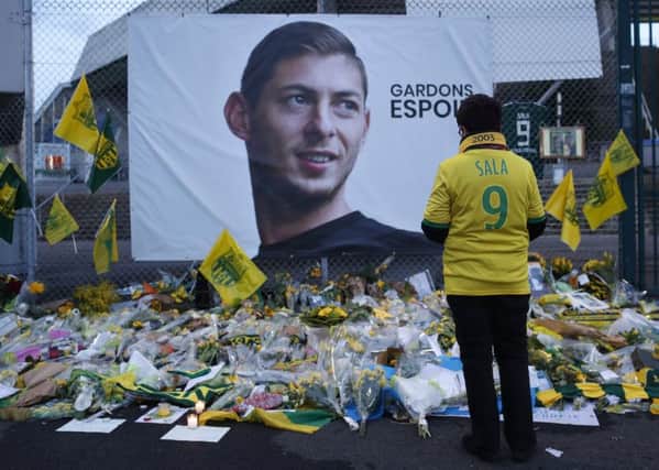 A Nantes fan stops by a poster of Emiliano Sala reading "Let's keep hope" outside La Beaujoire stadium. Picture: AP