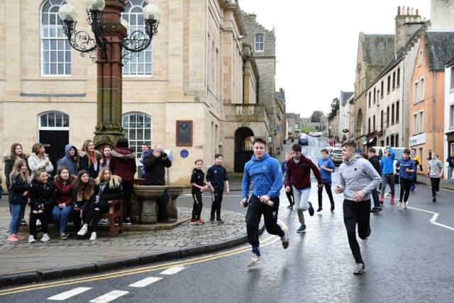 Boys run down the hill with the leather ball during the annual 'Fastern's E'en Hand Ba' event on Jedburgh's High Street.