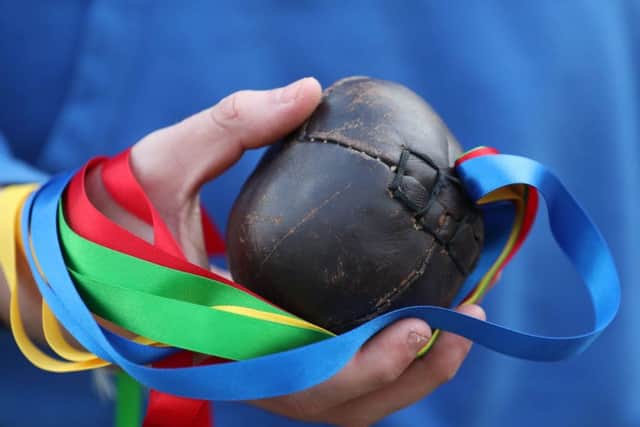 The leather ball is held during the annual 'Fastern's E'en Hand Ba' event on Jedburgh's High Street.