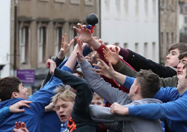 Boys tussle for the leather ball during the annual 'Fastern's E'en Hand Ba' event on Jedburgh's High Street in the Scottish Borders. PRESS ASSOCIATION Photo. Picture date: Thursday February 7, 2019. The annual event, which started in the 1700's, traditionally the first ever game was played with an Englishman's head, involves two teams, the Uppies (residents from the higher part of Jedburgh) and the Doonies (residents from the lower part of Jedburgh) getting the ball to either the top or bottom of the town. The ball, which is made of leather, stuffed with straw and decorated with ribbons representing hair, is thrown into the crowd to begin the game. Photo credit should read: Andrew Milligan/PA Wire