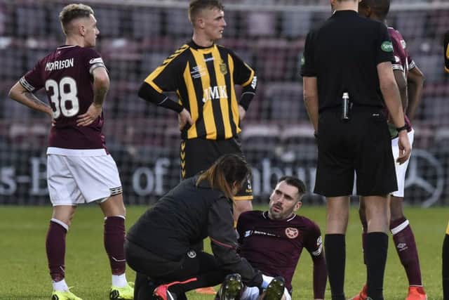 Michael Smith gets treatment before leaving the field with a torn thigh muscle. Picture: Dave Johnson