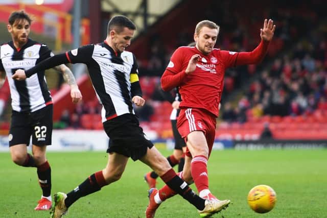 Paul McGinn plays the ball under pressure from Aberdeen forward James Wilson. Picture: SNS Group