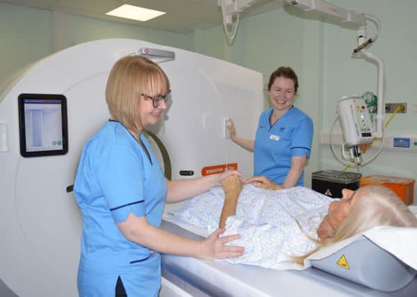 Staff operating a CT scanner