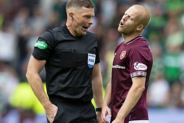 Referee John Beaton about to book Hearts' Steven Naismith. Picture: Ross Parker/SNS