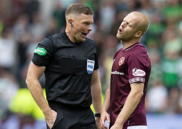 Referee John Beaton about to book Hearts' Steven Naismith. Picture: Ross Parker/SNS