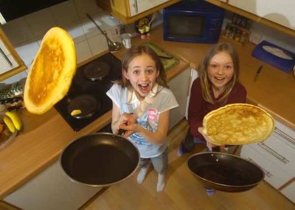 Sisters Emma left, and Joanne Russell, get some pancake-tossing practice in for Shrove Tuesday next week. Picture: Toby Williams