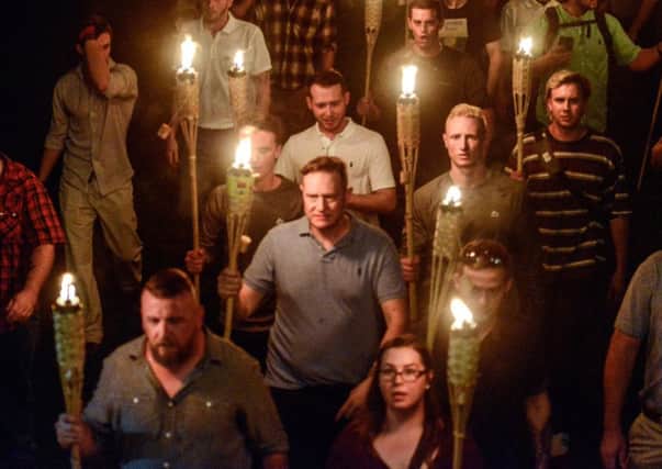White nationalists, including Cole White, in the striped top to the right, participate in the torch-lit march on the grounds of the University of Virginia in Charlottesville. Picture: 
Stephanie Keith/Reuters
