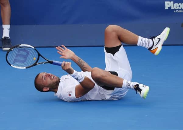 Dan Evans takes a tumbles during the final of the Delray Beach Open. Picture: Wilfredo Lee/AP