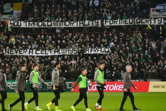 Celtic subs walk past the banner aimed at former manager Rodgers. Picture: SNS Group