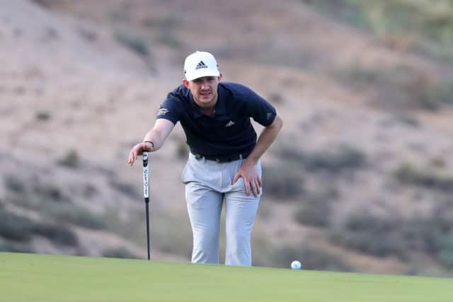 Connor Syme lines up a putt before play was suspended due to high winds in the second round of the Oman Open. Picture: Getty Images